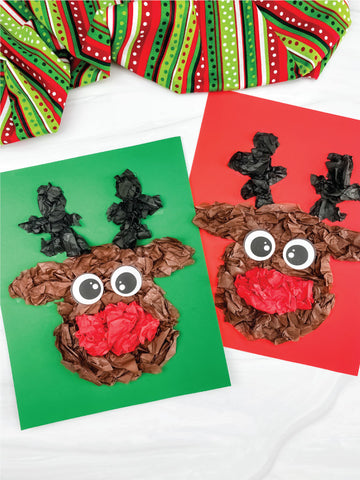 Two reindeer crafts made from tissue paper and glue on a white background with green and red fabric.