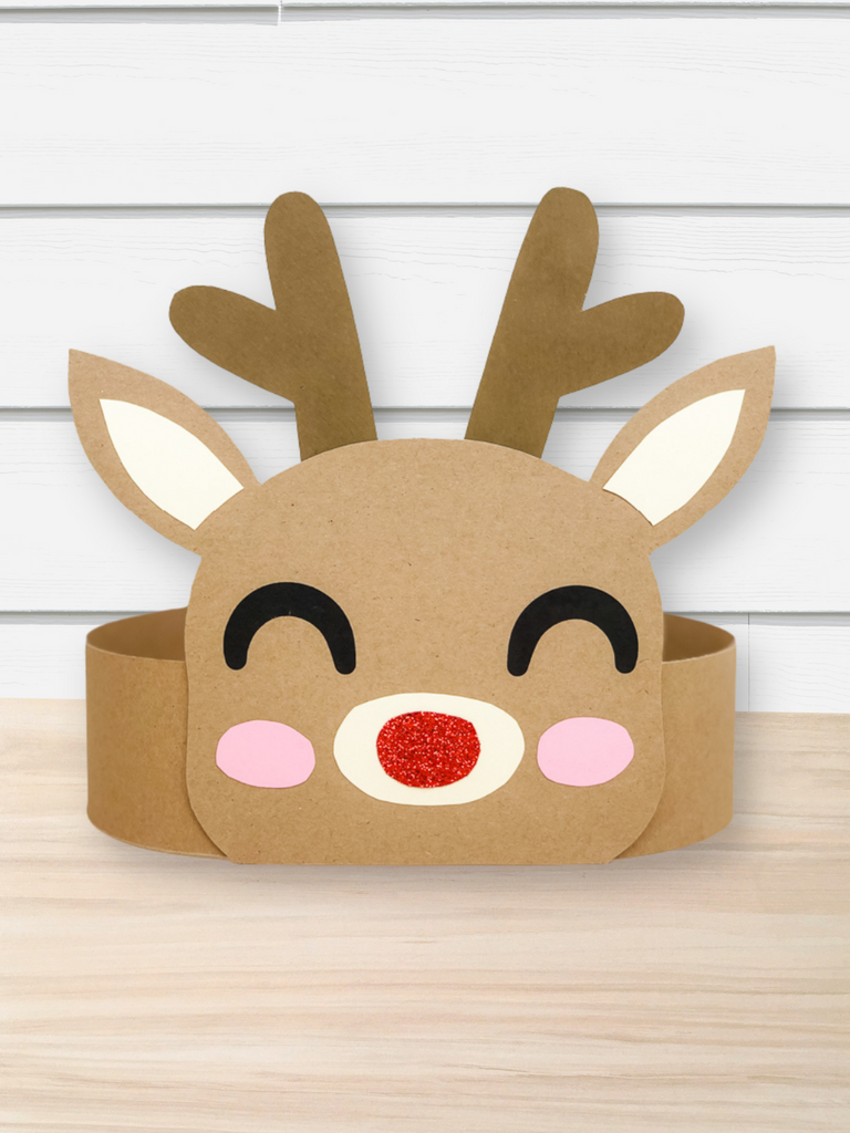 Reindeer face headband craft on a wooden surface with a white wooden panel background