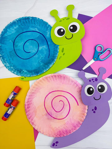 Colorful paper plate snails with craft supplies on a white background