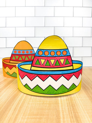 Colorful paper sombreros on a wooden surface with a white tiled wall background
