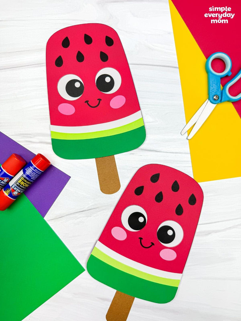 Colorful paper craft of a watermelon popsicle with smiling face on a white background.