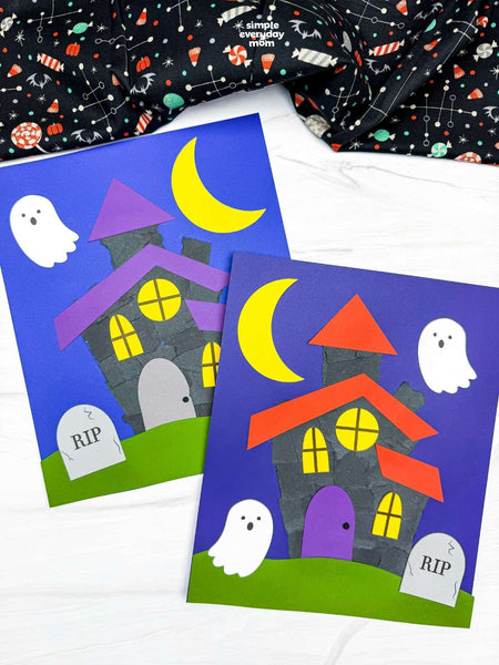 Two handmade Halloween craft featuring a haunted house, moon, ghosts, and tombstones, styled on a white wood surface with a patterned fabric in the background.