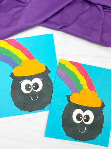 Two torn paper pot of gold crafts on white background with purple fabric on top