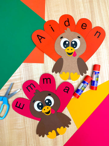 Children's name turkey crafts on a wood background with colorful papers 