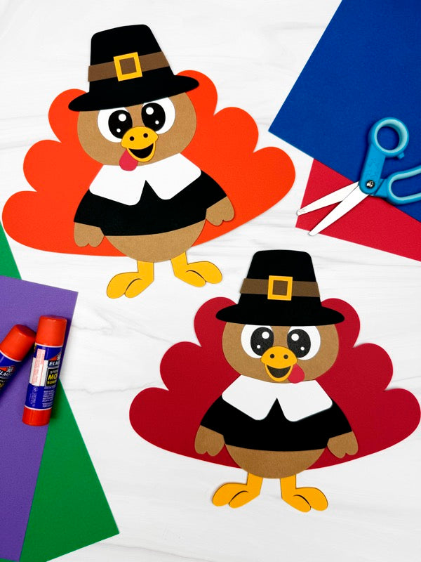 Two paper turkey cutouts with pilgrim hats on a colorful background with scissors and glue sticks.