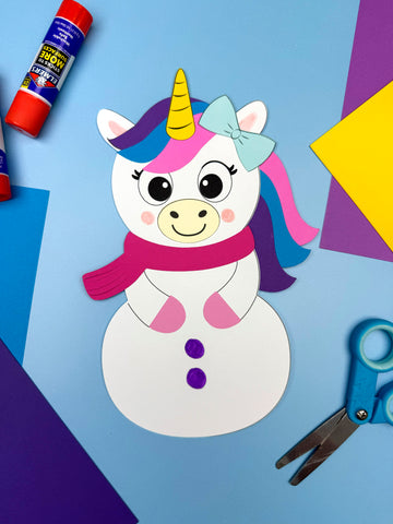 Colorful unicorn snowman craft on a blue background with scissors and glue sticks.
