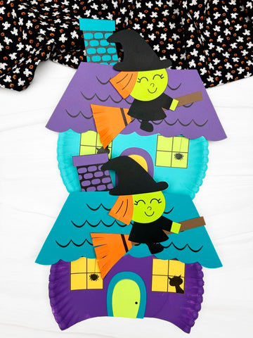 Witch house paper plate craft with witch figures on a white background with ghost fabric on top