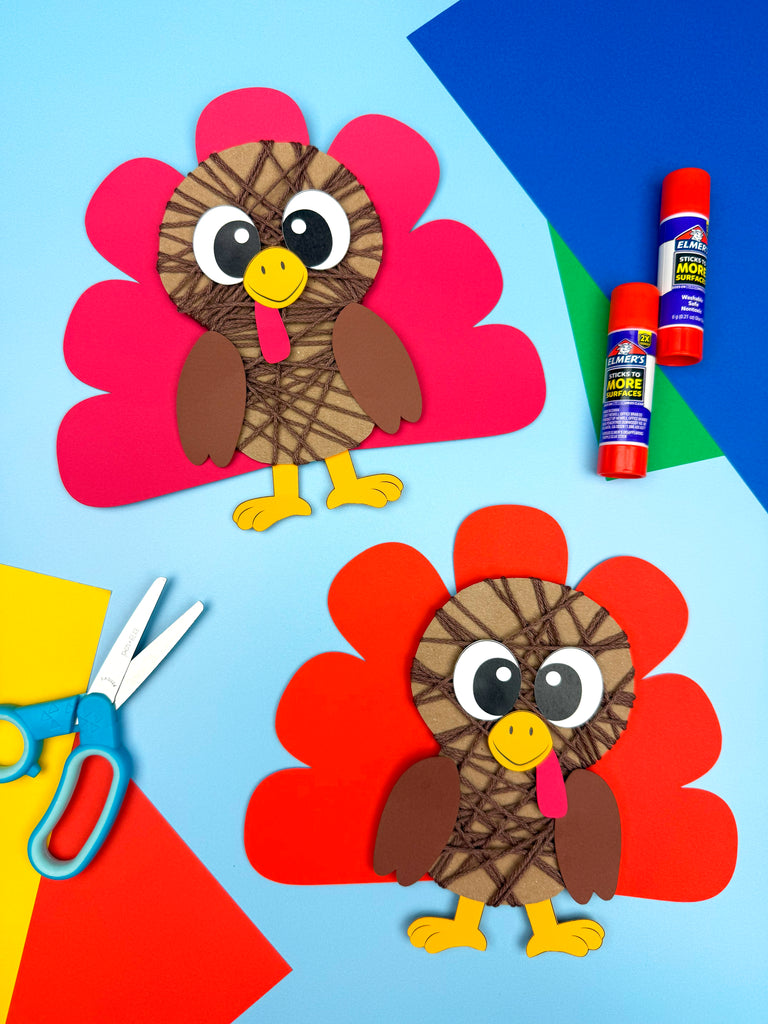 Two yarn wrapped turkey crafts with colorful feathers, glue, scissors, and markers on a blue background.