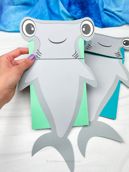hand holding hammerhead shark puppet craft with another one in the background