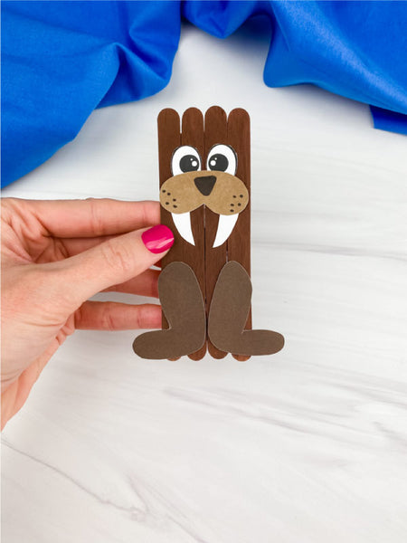 hand holding walrus popsicle stick craft